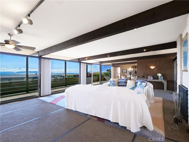 bedroom with a wall of windows, beamed ceiling, and rail lighting