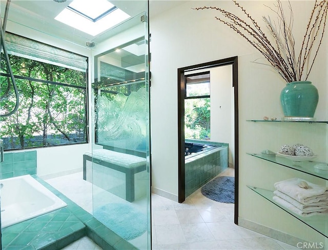 bathroom with tile patterned flooring, a garden tub, a skylight, and a stall shower