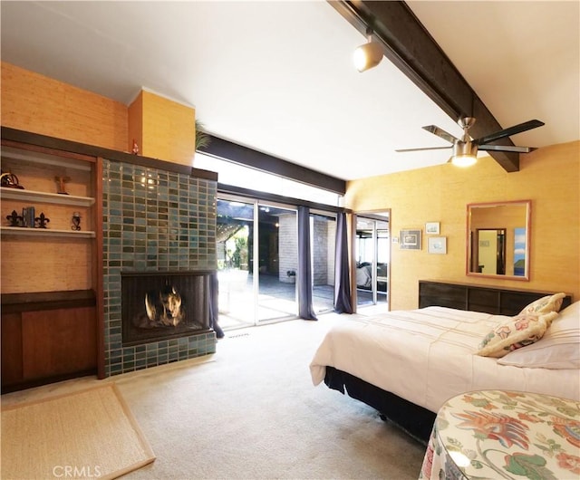 bedroom featuring access to exterior, ceiling fan, carpet floors, beam ceiling, and a fireplace