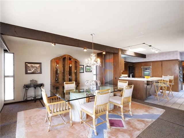 dining area featuring beamed ceiling, rail lighting, and a chandelier