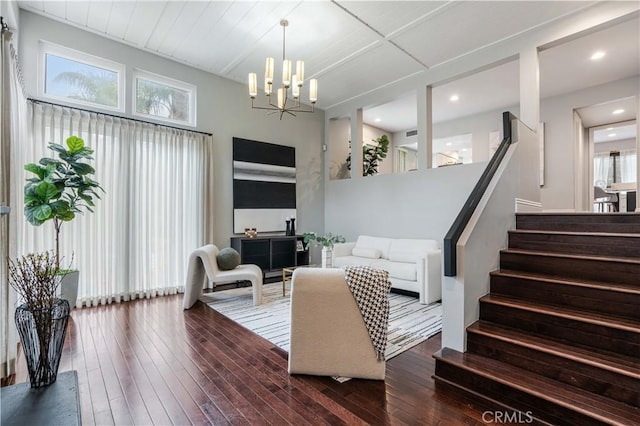 living area with hardwood / wood-style floors, stairway, and a chandelier