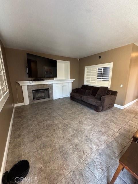 living room featuring visible vents, baseboards, and a high end fireplace