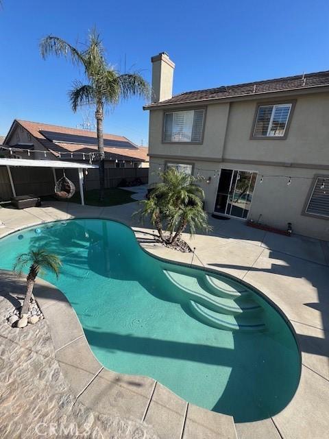 pool with fence and a patio area