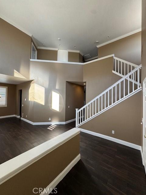 stairs featuring baseboards, wood finished floors, and crown molding