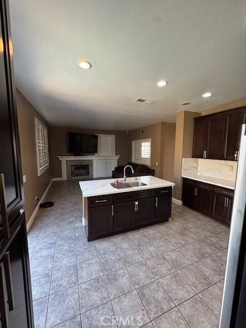 kitchen with open floor plan, light countertops, visible vents, and a sink