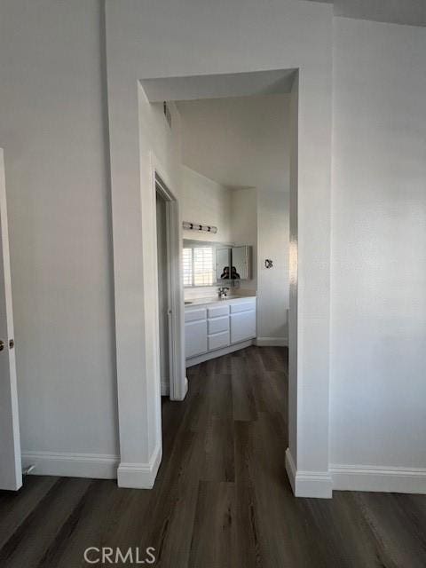 hall with baseboards and dark wood-style flooring