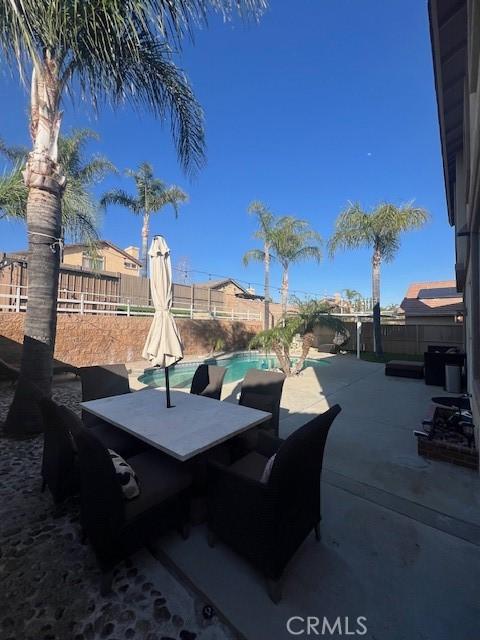 view of patio / terrace featuring outdoor dining area, a fenced backyard, and a fenced in pool