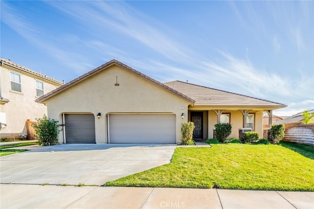 view of front of home featuring a tiled roof, concrete driveway, a front yard, stucco siding, and an attached garage