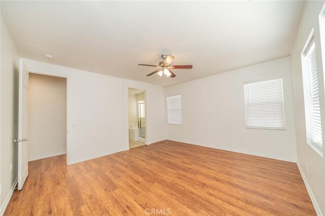 spare room featuring light wood finished floors, baseboards, and a ceiling fan