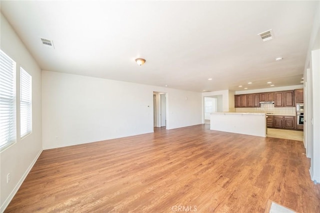unfurnished living room with light wood-style floors and visible vents