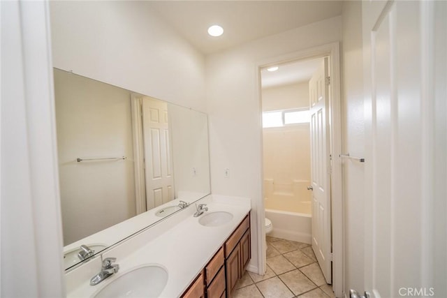 bathroom with a tub, double vanity, a sink, and tile patterned flooring