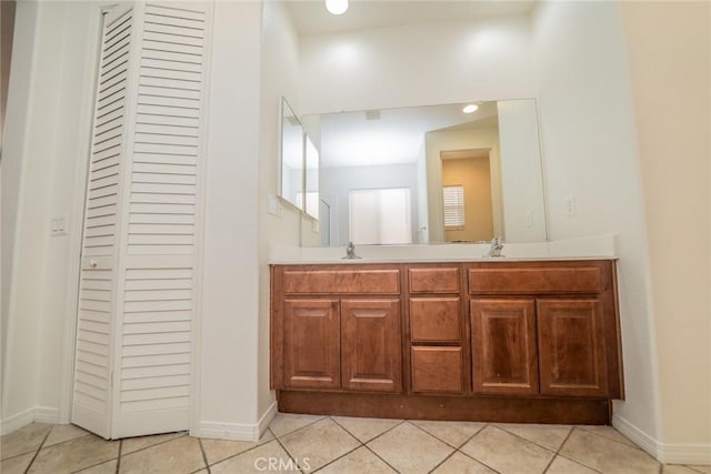 bathroom featuring double vanity, a sink, and tile patterned floors