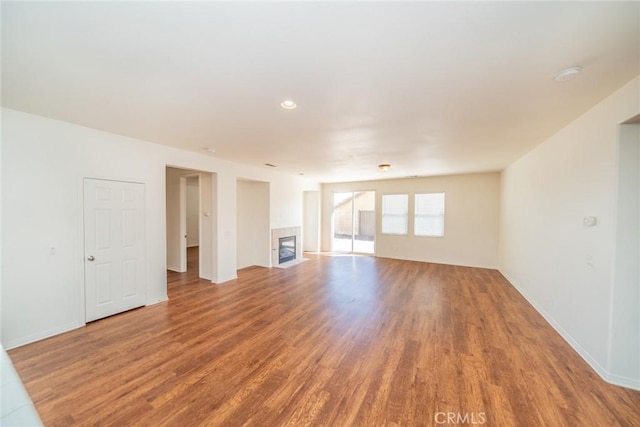 unfurnished living room featuring baseboards, a fireplace, and wood finished floors