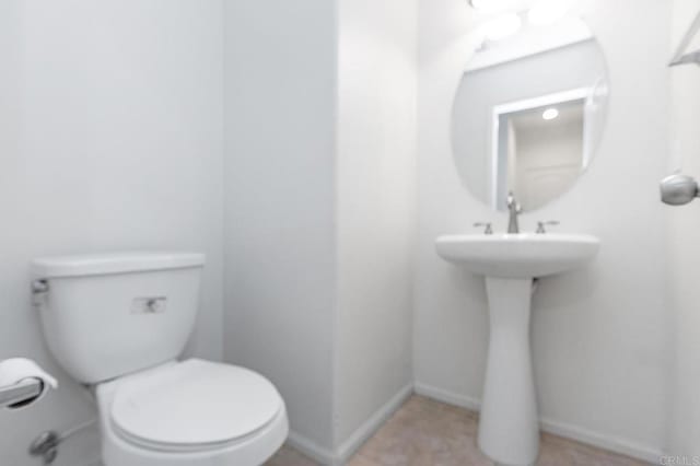 half bath with toilet and baseboards