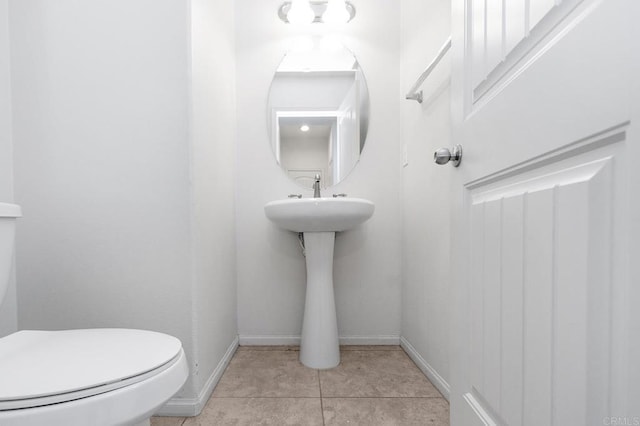 bathroom featuring tile patterned flooring, toilet, and baseboards