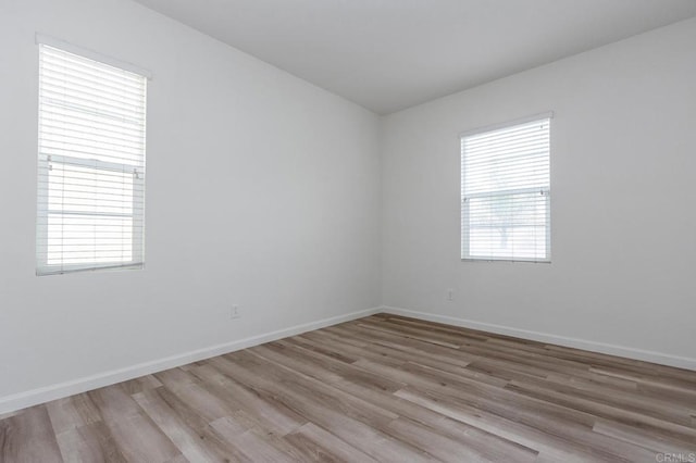 unfurnished room with wood finished floors and baseboards