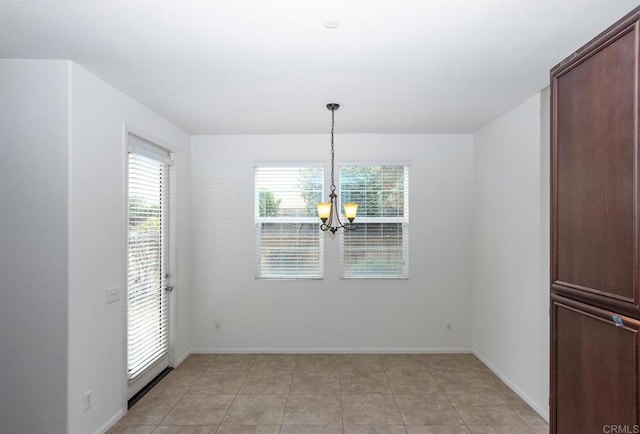 unfurnished dining area with light tile patterned floors, baseboards, and a notable chandelier