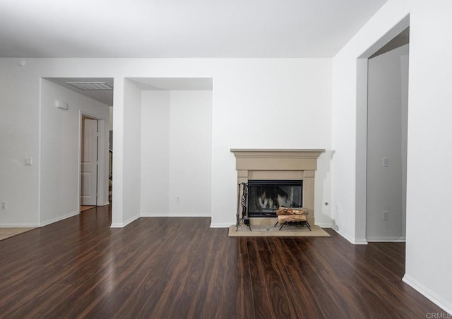 unfurnished living room with visible vents, baseboards, and wood finished floors