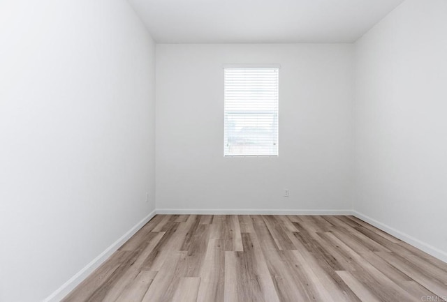 unfurnished room with light wood finished floors and baseboards