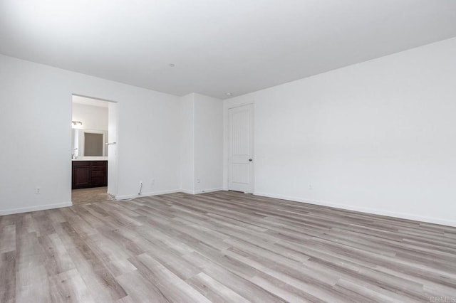 empty room featuring baseboards and light wood-style flooring