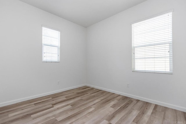 spare room with wood finished floors and baseboards