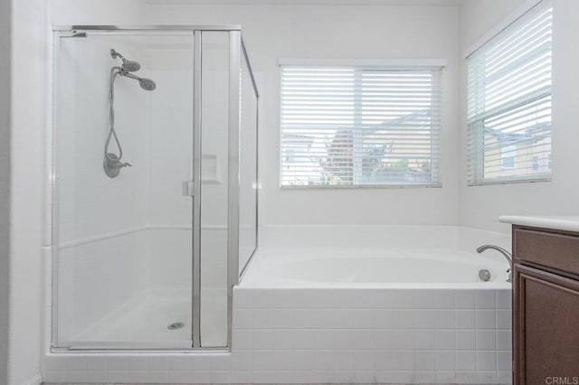 full bath with a stall shower, vanity, and a garden tub