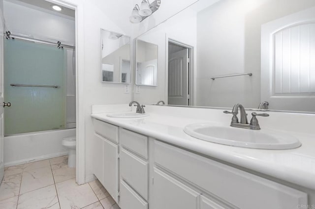 bathroom with double vanity, toilet, marble finish floor, and a sink