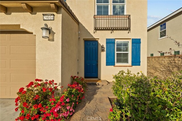 doorway to property with stucco siding and fence