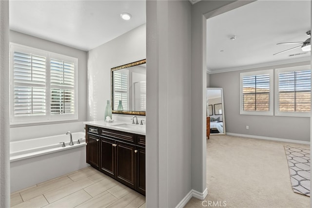 ensuite bathroom featuring connected bathroom, baseboards, a garden tub, vanity, and a ceiling fan