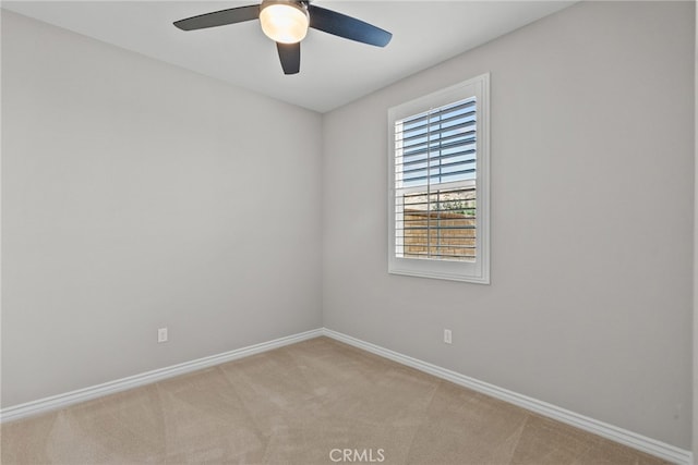 unfurnished room with baseboards, light carpet, and a ceiling fan