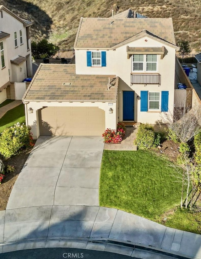 view of front of house with concrete driveway, a front yard, and stucco siding