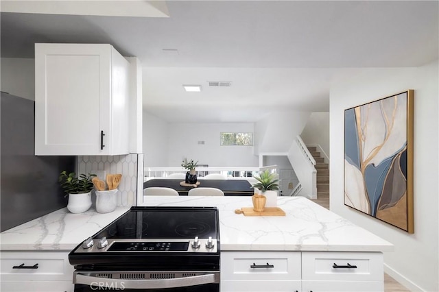 24877 Nueva Vista Dr Unit 23, Laguna Niguel, CA 92677 - kitchen featuring light stone counters, range with electric cooktop, and white cabinets