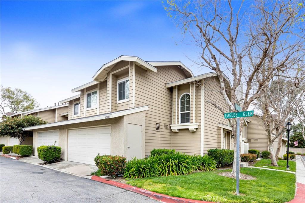 view of property with a front lawn, an attached garage, driveway, and stucco siding