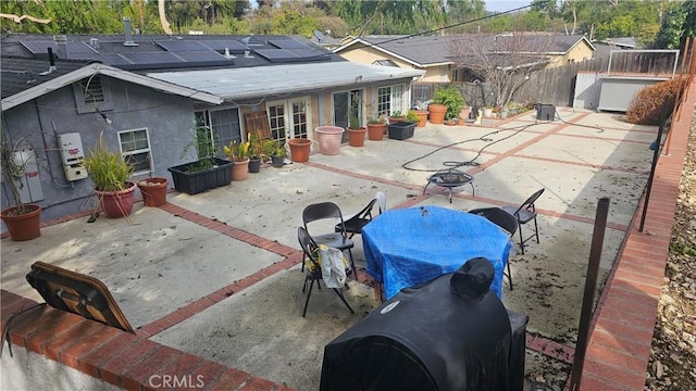 back of house featuring a patio, solar panels, a fenced backyard, stucco siding, and a fire pit