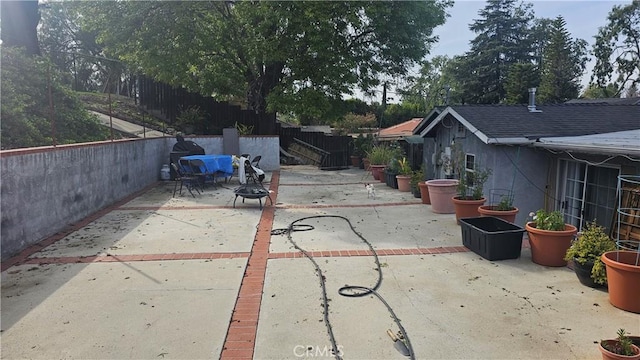 view of patio with a fire pit and fence