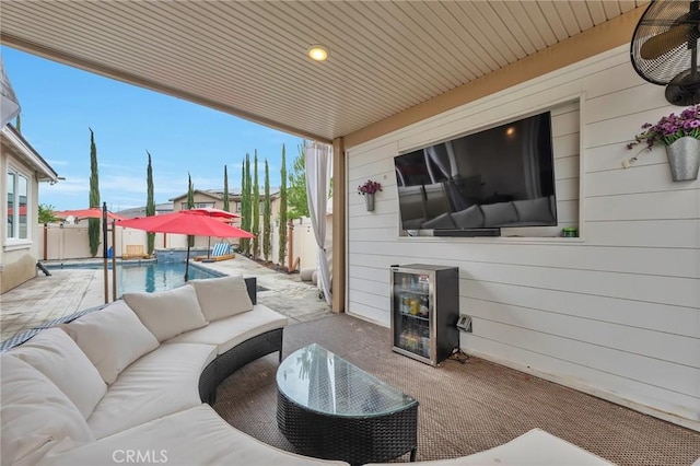 view of patio / terrace with wine cooler, a fenced in pool, outdoor lounge area, and fence