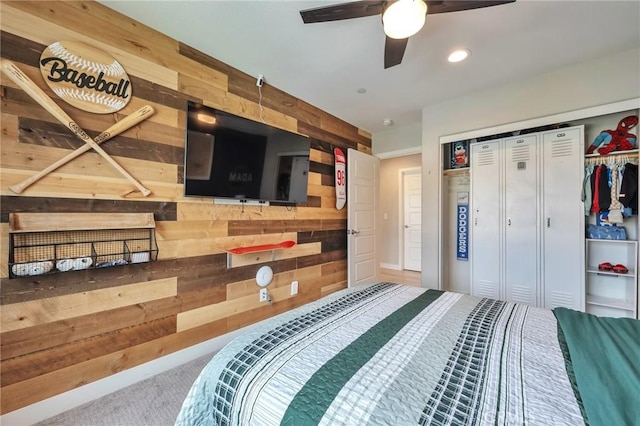 bedroom with a closet, recessed lighting, wood walls, and carpet floors