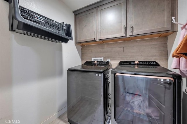 washroom featuring cabinet space, washing machine and dryer, and baseboards