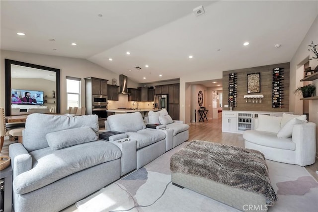 living room with recessed lighting, lofted ceiling, and light wood finished floors