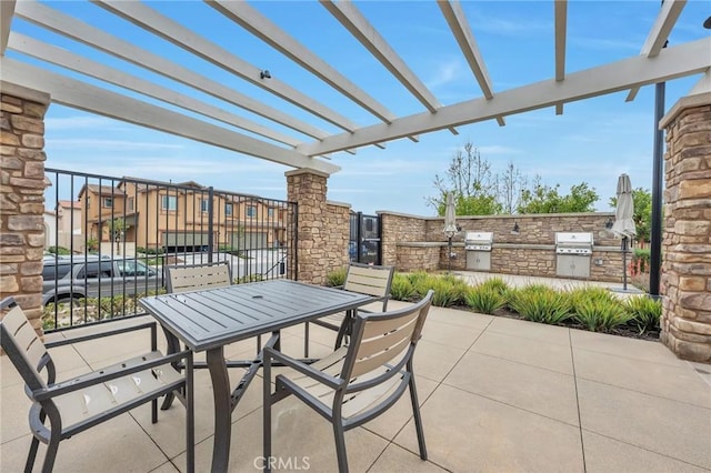 view of patio featuring exterior kitchen, outdoor dining area, a pergola, and a grill