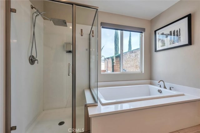 bathroom featuring a bath and a shower stall