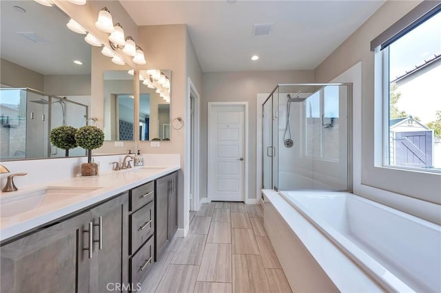 full bath with double vanity, visible vents, a stall shower, and a sink