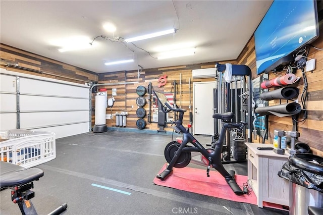 interior space featuring wood walls, an AC wall unit, and a garage