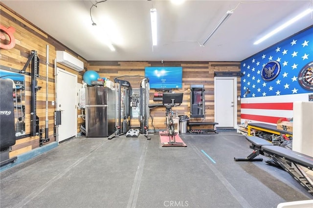 exercise area featuring wood walls, an AC wall unit, and a garage