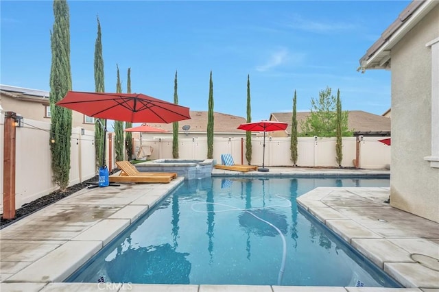 view of swimming pool with a patio, a pool with connected hot tub, and a fenced backyard