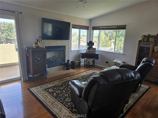 living room with a wealth of natural light, vaulted ceiling, and wood finished floors