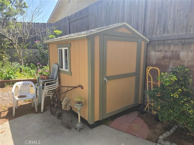 view of shed featuring fence