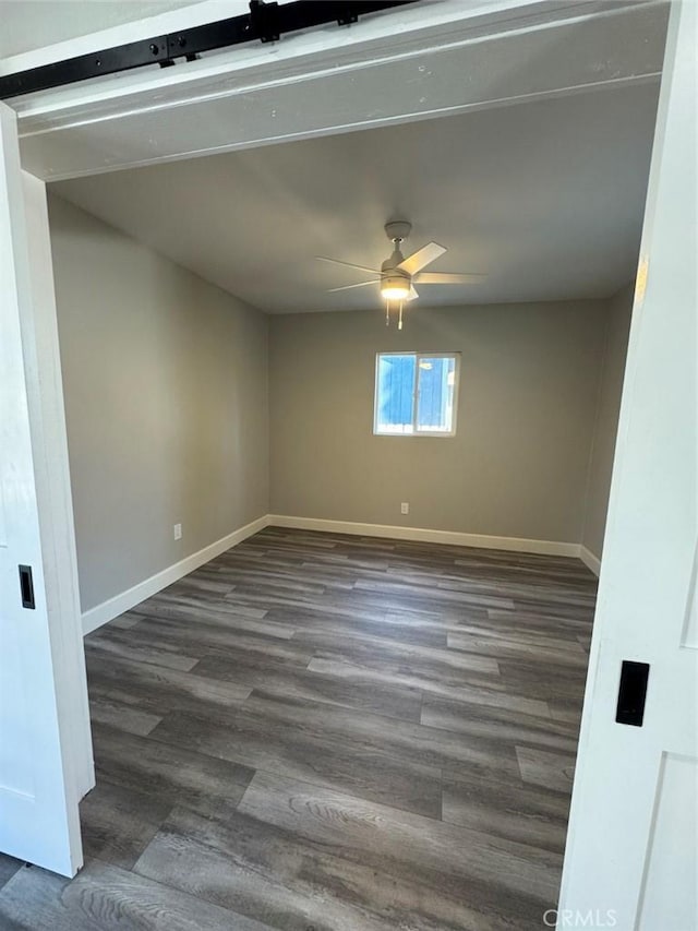 unfurnished room with baseboards, ceiling fan, and dark wood-style flooring