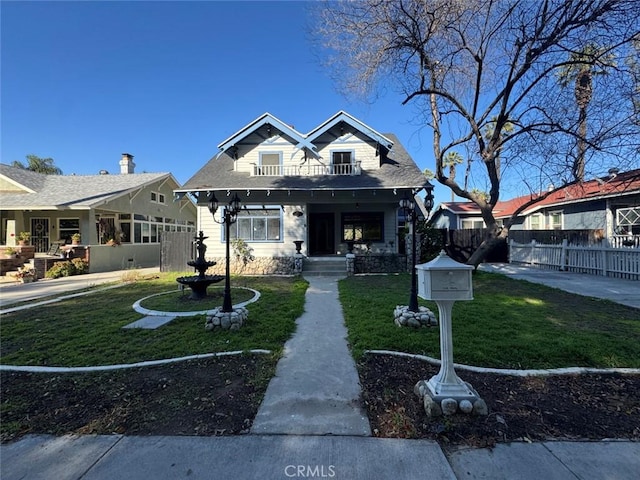 bungalow-style home with a front yard and fence