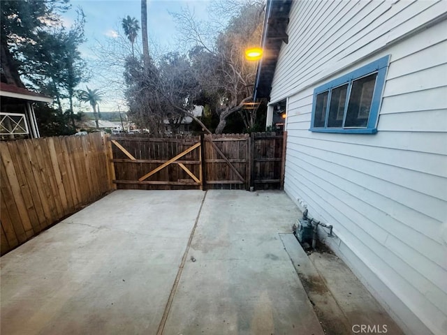 view of patio with a gate and fence